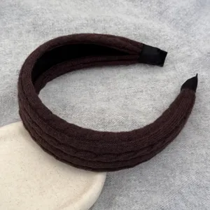 Gros plan d'un bandeau large en tricot marron avec texture torsadée pour l'hiver.