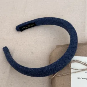 Vue détaillée d'un serre-tête rembourré en tricot bleu marine au style minimaliste.