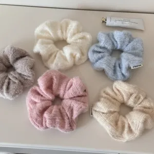 Nahaufnahme weicher Strick-Haargummis in Pastelltönen mit hochwertigen Strukturen.