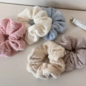 Detailaufnahme von weichen gestrickten Haargummis in verschiedenen pastellfarbenen Wintertönen