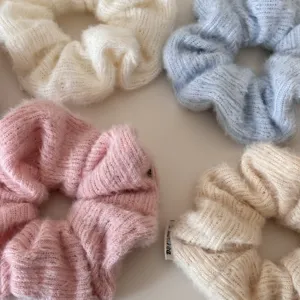 Detailansicht weicher Strick-Scrunchies in Pastellfarben für stilvolle Winterfrisuren