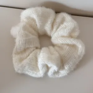 Detailansicht der weichen weißen Strickstruktur dieses Winter-Haargummi-Accessoires