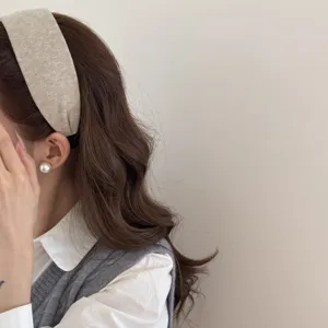 Détail de vue latérale d'un bandeau large en tissu beige rétro pour une coiffure élégante