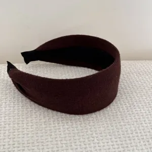 Vue détaillée de la texture tricotée de ce bandeau vintage large marron foncé uni