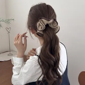 Detail shot of a minimalist Korean style ruffle hair scrunchie on wavy brown hair