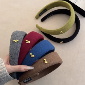 Detalle de diademas de lana acolchadas con elegantes lazos dorados en varios colores