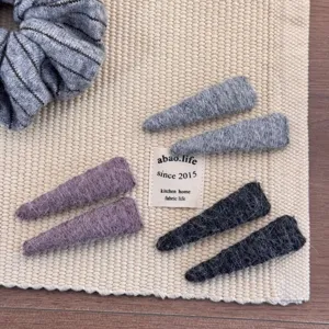 Close-up detail of soft wool felt hair clips in assorted cozy autumn colors for girls