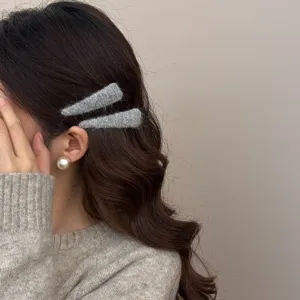 Set of two minimalist grey felt wool hair clips shown on model for autumn winter