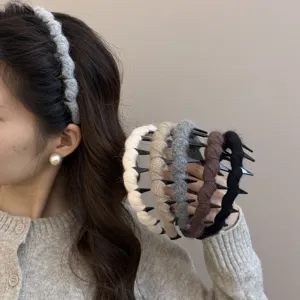 Modelo con diadema de punto gris con dientes y sujetando varias opciones de color