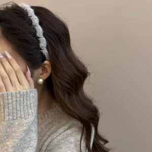 Vista detallada de una diadema de punto gris con ondas llevada por una modelo real