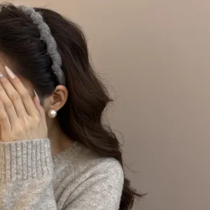Primer plano de una diadema de punto gris ondulada usada por una modelo para el invierno.