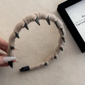 Detalle de una diadema de punto beige con dientes antideslizantes de plástico negro
