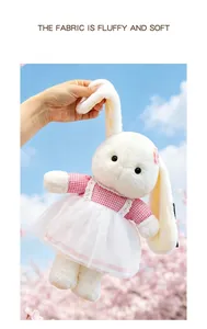 Detail of soft plush rabbit doll with long ears wearing a pink checkered dress