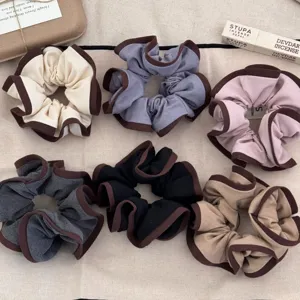 Set of 6 ruffed edge scrunchies in various colors for hair styling.