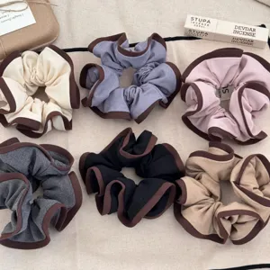 Elegant wood-ear ruffled scrunchies in six soft colors with contrasting brown edges.