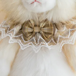 Close-up detail of the lace collar and plaid bow tie on a plush ragdoll cat doll.