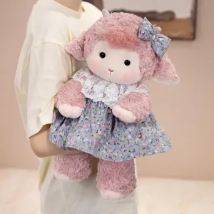 Cute pink plush lamb doll wearing a floral print dress with a lace collar detail
