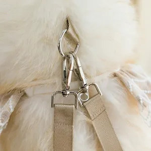 Close-up of silver metal lobster clasps and beige straps on a plush cat doll bag toy