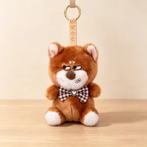 Cute grumpy brown animal plush keychain with checkered bow tie and heart detail