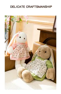 Zwei niedliche Plüschhasen mit Blumenkleidern sitzen gemütlich auf einem braunen Sofa