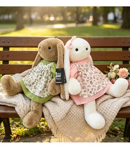 Twee schattige pluche konijnen in bloemenjurken die op een gezellige parkbank zitten.