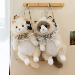 Detail view of two cat plush backpacks with lace collars hanging on wall hooks.