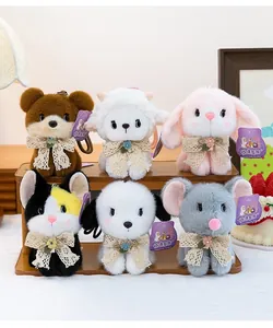 Group of cute plush animal keychain charms displayed on a wooden stand