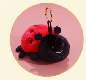 Detailed macro shot of cute plush ladybug keychain with smiling face and soft red fur