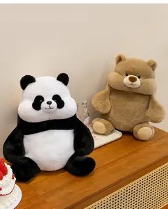Close-up of adorable chubby panda and brown bear plush toys sitting on a wooden table