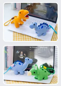 Vista detallada de coloridos llaveros de dinosaurio de peluche en un teclado blanco