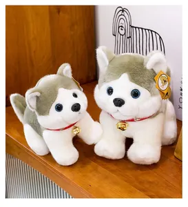 Detalle de peluches husky con collares rojos y campanas doradas sobre madera