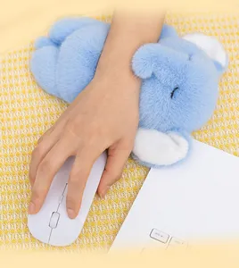 Primo piano di un poggiapolsi in peluche a forma di elefante blu usato con un mouse da ufficio.