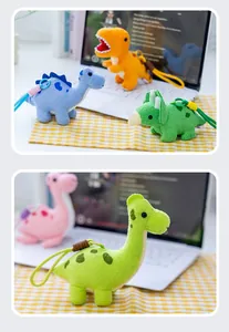 Primer plano de lindos llaveros de dinosaurios de peluche sobre un escritorio claro
