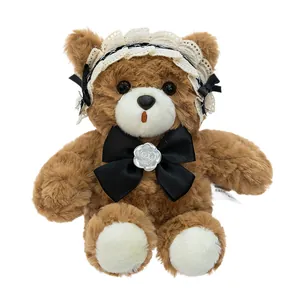 Adorable oso de peluche de chocolate marrón con gorro de encaje blanco y pajarita negra