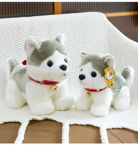 Peluches de husky adorables con collares rojos y cascabeles sobre una manta suave