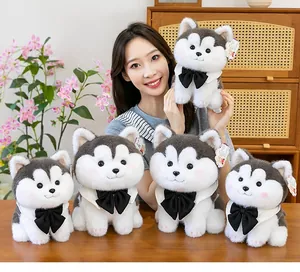 Close-up of a woman holding a cute husky plush toy with several others on a table