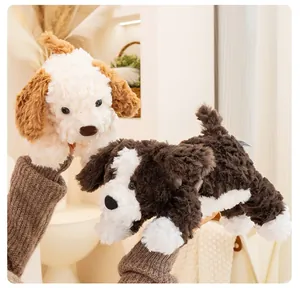 Primo piano di due morbidi peluche di cucciolo marrone e bianco tenuti in mano in ambiente caldo.