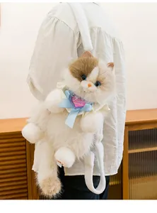 Detailansicht des dreifarbigen Katzen-Plüschrucksacks mit süßer Schleife und Herzanhänger.