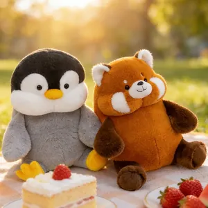 Adorable chubby penguin and red panda plush toys sitting on a sunny outdoor picnic mat with cake