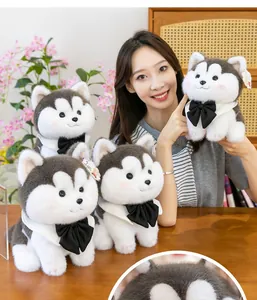 Macro view of cute husky plush toys featuring black bow ties and white collars for children