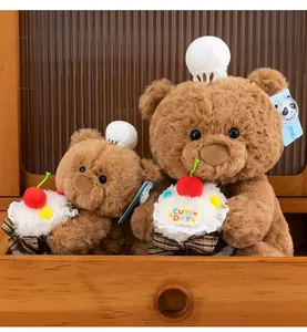 Dettaglio di due orsetti di peluche marroni con cappelli da chef e cupcake