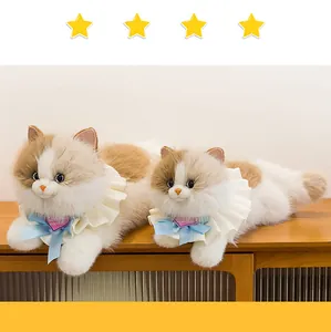 Detailaufnahme süßer Calico-Katzen-Plüschpuppen mit blauen Bändern und weißen Rüschen