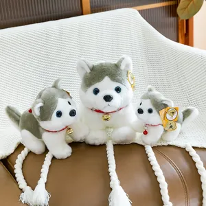 Set de 3 peluches de Husky con collares rojos y cascabeles sobre manta blanca.