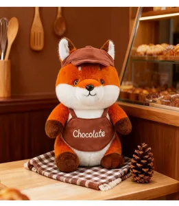 Detailed view of cute fox plush toy wearing a chocolate embroidered brown apron