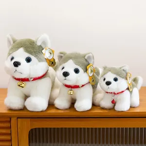 Tres lindos peluches de husky de diferentes tamaños con collares rojos sobre madera.