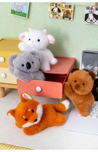 Group of cute lying animal plush toys including fox and koala on a desk setup