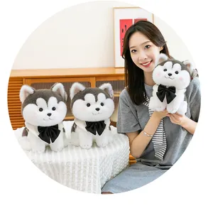 Detailed view of the cute husky plush toy featuring a black bow tie, held by a smiling model.