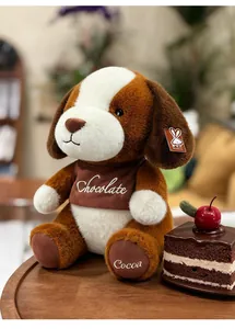 Niedlicher Maillard brauner Hunde Plüschtier mit Schokoladenkuchen in gemütlichem Raum