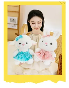 Detailed view of cute white lamb and rabbit plush dolls wearing blue and pink dresses