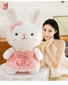 Detail of a large white plush bunny wearing a pink princess bow dress with a model